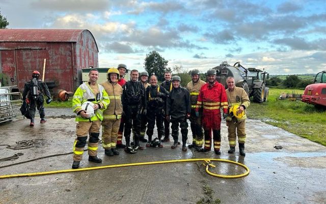 John Holmes (center) poses for photographs with his colleagues after rescuing 28 calves on Monday evening. 