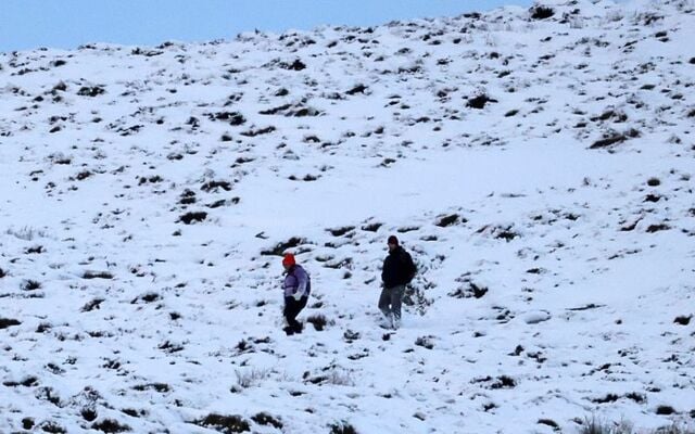 November 20, 2024: A couple makes their way down the Tonlegge mountain in the snow in Co Wicklow. 