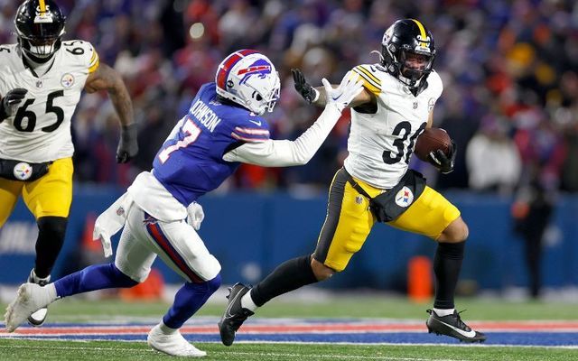 January 15, 2024: Jaylen Warren #30 of the Pittsburgh Steelers carries the ball against Taron Johnson #7 of the Buffalo Bills during the second quarter at Highmark Stadium in Orchard Park, New York