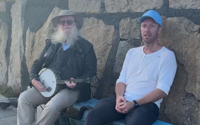 Coldplay frontman Chris Martin with a busker in Dún Laoghaire.